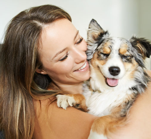 Woman hugging a smiling dog